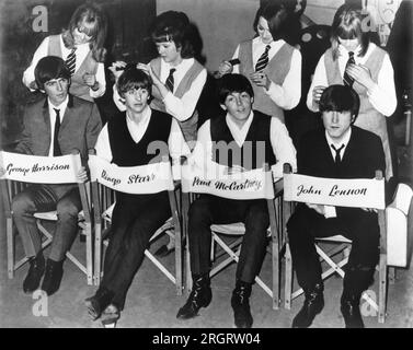 1964 The Beatles are attended to by individual hairdressers during a break in the filming of 'A Hard Day's NIght'. Stock Photo