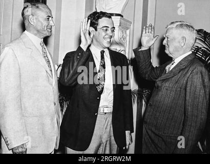 Washington, D.C.:   June 21, 1935 Vice President John Garner administers the oath for Rush Holt to take his seat in the Senate. Although Holt was elected in West Virginia last November, he had to wait until June 19th when he turned the required age of 30 to be able to take his seat in the Senate. Senator M.M. Neeley of West Virginia stands by at the left. Stock Photo