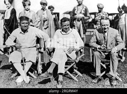 Hollywood, California:   July 12, 1923 Douglas Fairbanks, left, directing the Pickford Fairbanks Studio's latest film, 'The Thief Of Bagdad'. Center is Rauol Walsh aiding in the direction, and right is Edward Knoblock, author and playwright. Stock Photo