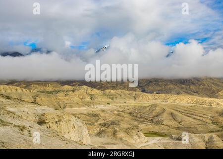 Foggy Himalayan Mountain and Desert of Upper Mustang in Nepal as seen from Lho La Pass Stock Photo