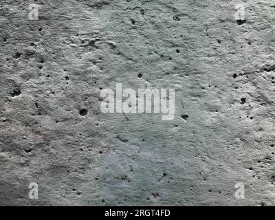Texture of a light gray concrete wall with holes, strokes, granules, scratches and scuffs. For design and decoration. Photo Stock Photo
