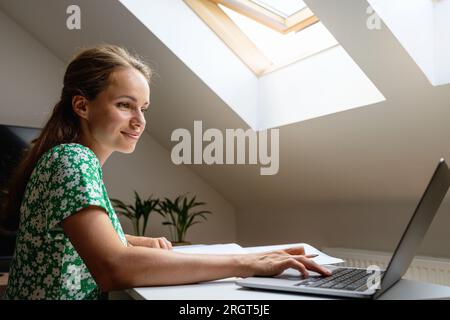 Adult female university student studying at home using e-learning university's platform for the distance education. Stock Photo