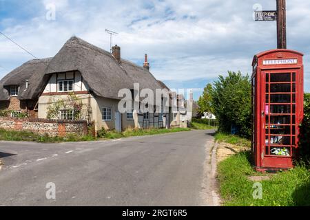 Red phone box in Longstock village with historic old sign reading Telephone Telegrams may be Telephoned, Hampshire, England, UK Stock Photo