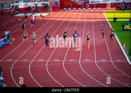 B. BYSTRICA, SLOVAKIA, JULY 20, 2023: Women Participate in 100m Sprint Amidst Beautiful Sunset Illumination at Track and Field Championship for Worlds Stock Photo