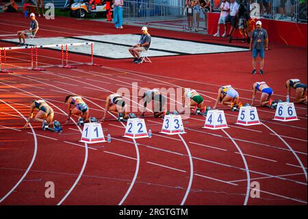 B. BYSTRICA, SLOVAKIA, JULY 20, 2023: Female Sprinters Commence 100m Race from the Starting Line: Track and Field Competition Scene for Worlds in Buda Stock Photo