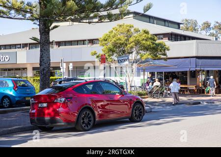 Red Tesla Y 2023 year EV driving through AVALON BEACH in Sydney,NSW,Australia Stock Photo