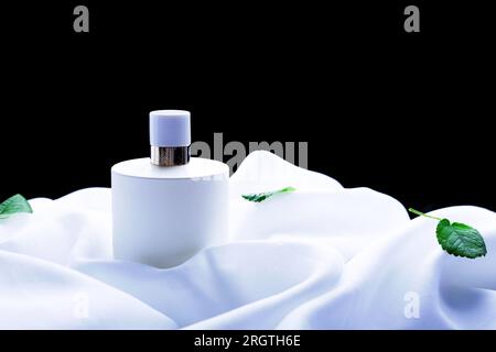 Perfume on a background of white fabric in waves Stock Photo