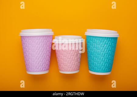 Colored cardboard coffee cups on a bright background Stock Photo