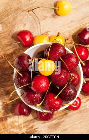 fresh edible berries, berries with bones and tails, delicious sweet cherries washed and therefore covered with drops of water, together with red berri Stock Photo