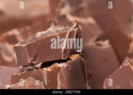 natural food from cocoa, sugar, cocoa butter, closeup pieces of large natural real chocolate, broken into several parts pieces of chocolate from cocoa Stock Photo