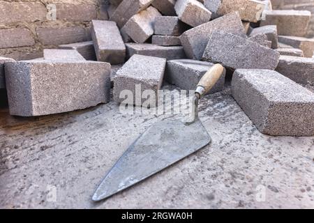 trowel and bricks on the concrete floor small business building a wall Stock Photo
