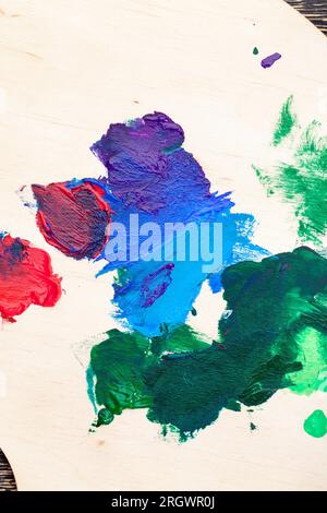 mixed on a wooden palette of multi colored paints, the paint is used for creative painting of paintings, real colored paints for hobbies and creative Stock Photo