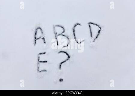painted letters and a question mark on the snow in the winter season in nature Stock Photo