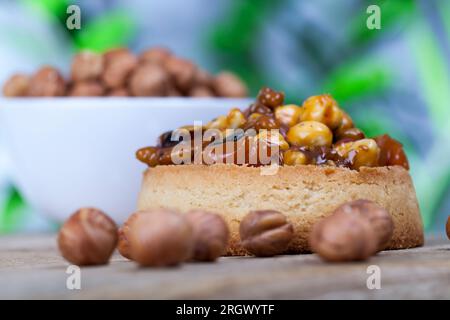 crispy tartlet with hazelnuts, peanuts and other ingredients, wheat dough tartlet with nuts and dried fruits in cream caramel, wheat tartlet with swee Stock Photo