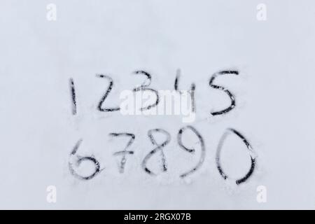 drawn numbers on the snow in the winter season in nature Stock Photo