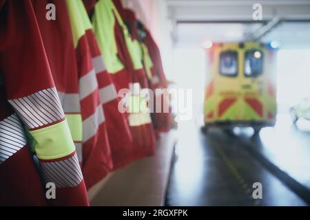 Close-up of paramedic uniforms and ambulance car of emergency medical service. Themes emergency medicine, rescue, and urgency help. Stock Photo