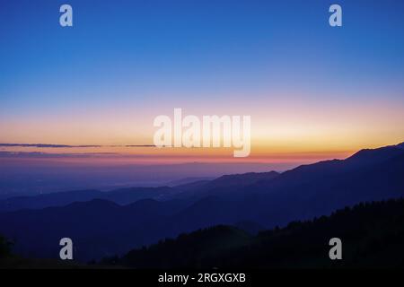 Silhouettes of mountain ranges in the early morning. Blue hour Stock Photo