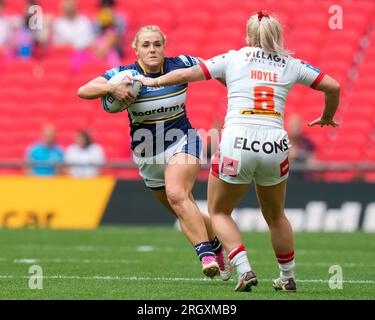 Amy Hardcastle #11 of Leeds Rhinos drives through a tackle during the ...