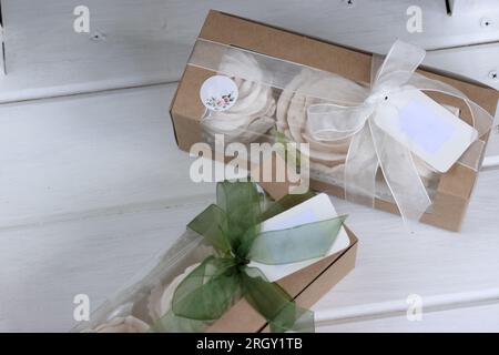 Homemade marshmallows in paper gift boxes. Zephyr flowers. The boxes are tied with a ribbon tied into a bow. Tag for text. Stock Photo