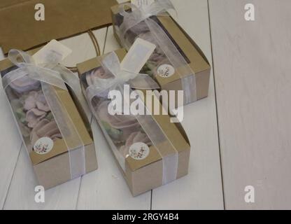 Homemade marshmallows in paper gift boxes. Zephyr flowers. The boxes are tied with a ribbon tied into a bow. Three boxes. Stock Photo