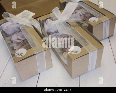 Homemade marshmallows in paper gift boxes. Zephyr flowers. The boxes are tied with a ribbon tied into a bow. Three boxes. Stock Photo