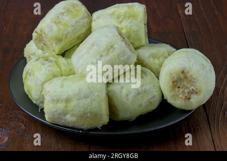 Closeup of peeled prickly pears on black plate on dark brown wooden table Stock Photo