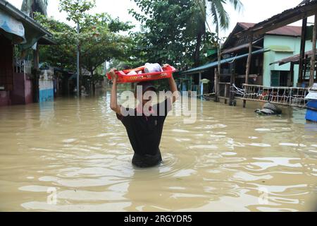 Bago, Myanmar. 12th Aug, 2023. A man wades through flood water in Bago, Myanmar, Aug. 12, 2023. Myanmar's Department of Disaster Management said on Friday that more than 45,000 people were currently in the flood shelters across the country due to floods triggered by surging river levels and intense rainfall in recent days.TO GO WITH 'Roundup: Over 45,000 displaced as floods, landslides hit Myanmar' Credit: Myo Kyaw Soe/Xinhua/Alamy Live News Stock Photo