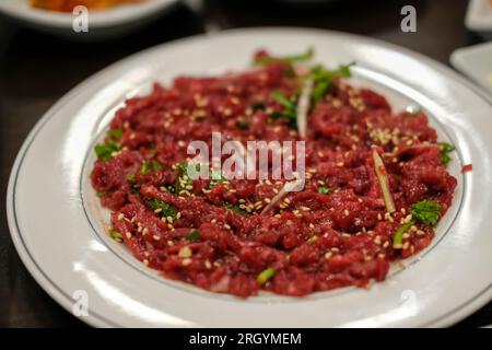 Yukhoe, a raw beef meat sliced and seasoned with salt, sugar, sesame oil, pepper, and garlic, etc. It is famous Korean food. Stock Photo