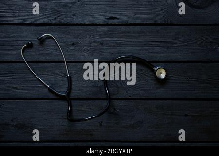 Stethoscope lies on a black wooden board close-up ,health and medicine Stock Photo