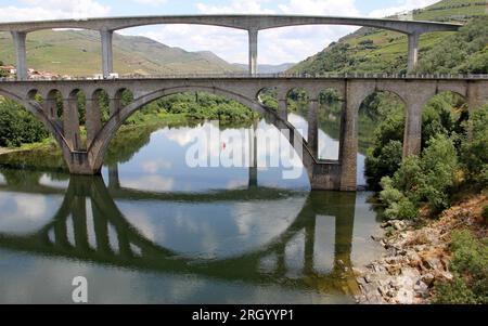 Bridges across Douro River east of Porto in the Portuguese wine region, terraced vineyards on hillslopes in the background, Peso da Regua, Portugal Stock Photo