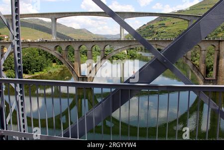 Bridges across Douro River east of Porto in the Portuguese wine region, terraced vineyards on hillslopes in the background, Peso da Regua, Portugal Stock Photo