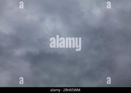 Atmosphere and formation of rain. Low hanging clouds with rain on the background of a gray sky. Rain clouds, texture, background. Gray sky Stock Photo