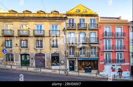 Colorful historic buildings with iron balconies on steep Calçada do Combro street, traditional Lisbon neighborhood architecture Portugal Stock Photo