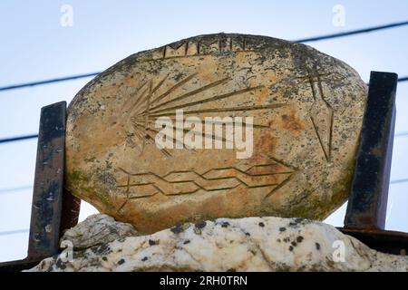 A stone with etched markings outside a private residence show pilgrims the way along the Camino Frances in Astorga, Leon, Spain. The scallop shell and Stock Photo