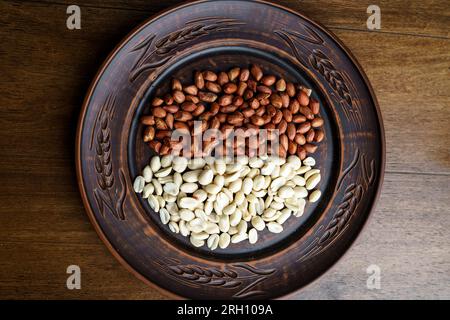 Raw peanuts in a clay bowl. Cajour and shelled beans Stock Photo