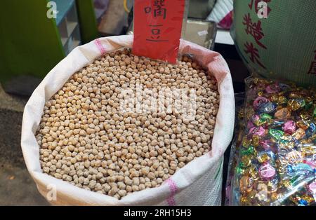 heap of raw fresh chickpeas (Cicer arietinum) in bulk Bags, in the corner of the traditional retail store. Stock Photo