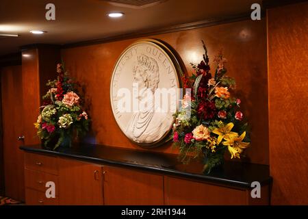 LONG BEACH, CALIFORNIA - 14 JUN 2023: Plaque with a portrait of Queen Mary behind the reception desk of the ocean liner converted into a hotel Stock Photo