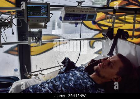 Wounded Ukrainian soldier is evacuated in a special medical bus, operated by volunteers of Hospitallers paramedic organisation. The Hospitallers are a Ukrainian volunteer magical battalion that has been providing first aid and evacuating wounded Ukrainian soldiers from the war zone since 2014. The medically equipped bus of Hospitallers - named “Austrian,” the nickname of a Hospitaller paramedic who was killed in a crash of another medical evacuation bus - can carry six severely wounded patients on stretchers, and several more walking wounded. Stock Photo