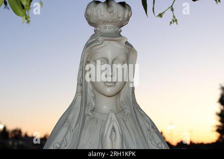 'Divine Serenity-A captivating marble statue of a woman in prayer, evoking a profound sense of peace and spiritual contemplation.' Stock Photo