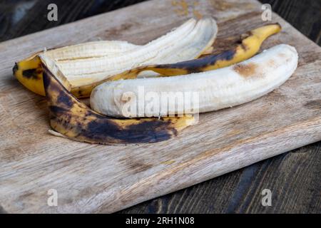 old blackening banana on a cutting board, perishable banana fruit food Stock Photo