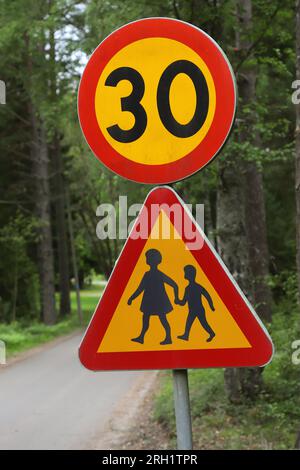 Close-up of beware of children and speed limited to thirty on a rural gravel road. Stock Photo