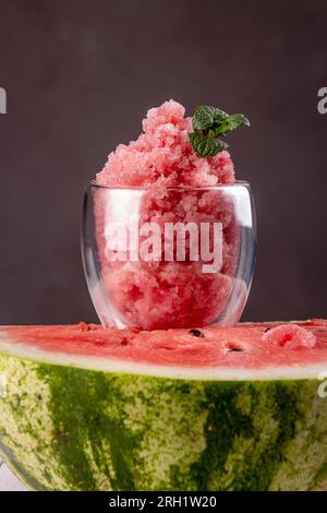 Watermelon sorbet in glass on top of half of ripe watermelon. Summer refreshing dessert. Front view Stock Photo