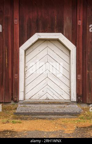 Old white wooden door on a red wooden building in Finland Stock Photo