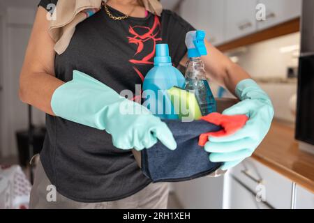 Senior woman with a set of cleaning supplies prepared to do the cleaning of the home. Stock Photo