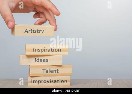 Artistry concept. Hand places the wooden rectangles next to the others, creating a wall of wooden cubes with the words Inspiration, Ideas and Stock Photo