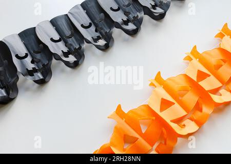 Trick or Treat concept. Holiday composition with halloween garland decorations skulls and pumpkins isolated on white background. Preparation for Hallo Stock Photo