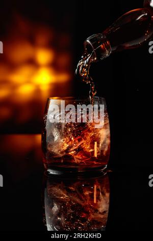 Premium Photo  Pouring whisky from a jigger into a rocks glass with a big  ice cube