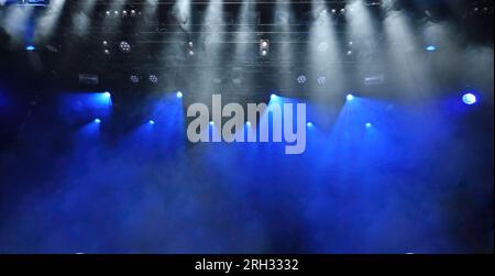 abstract background of stage lights with a blue and white ceiling spotlights and Stage mist working during the concert Stock Photo