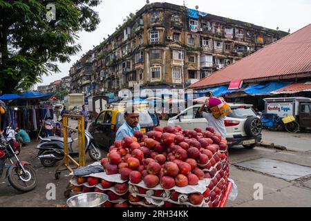 MUMBAI - SEPT 22: Indian seller with red apples on a tray in a local street market of Mumbai on September 22. 2022 in India Stock Photo