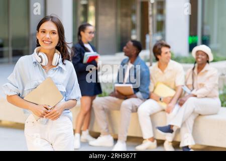 Pretty young woman posing over multiracial group of students Stock Photo